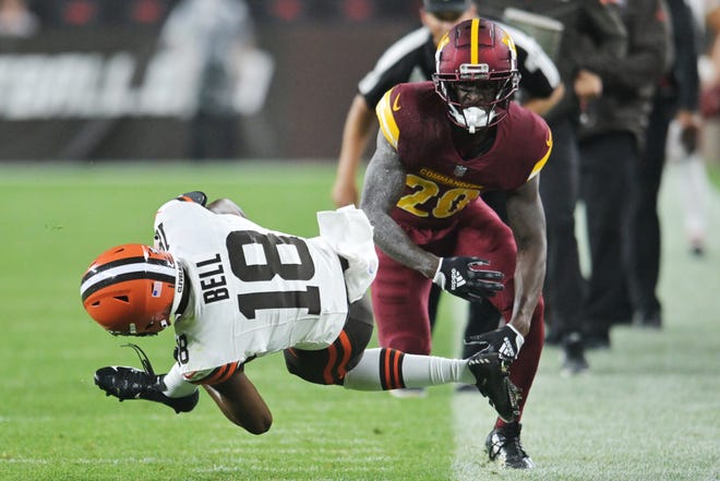 Cleveland Browns wide receiver David Bell (18) is tackled by Washington Commanders safety Jartavius Martin (20) during the first half at Cleveland Browns Stadium.