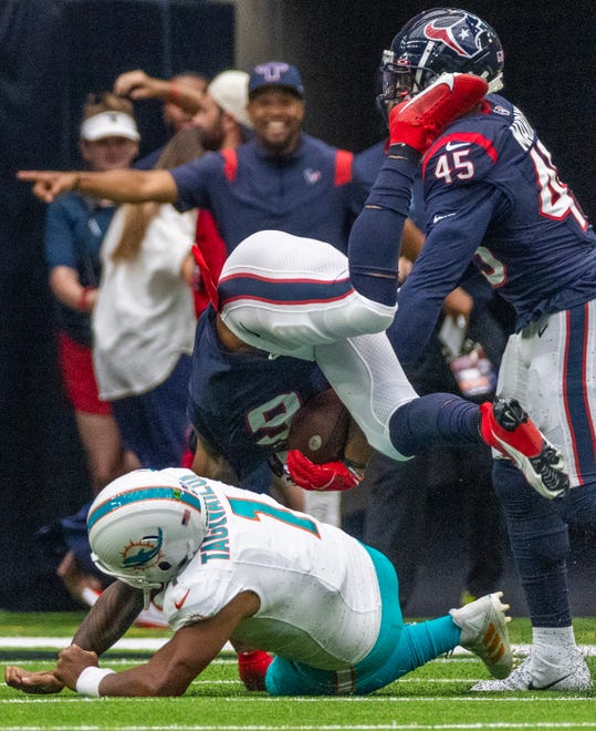 Aug. 19: Houston Texans linebacker Denzel Perryman (6) is tackled by Miami Dolphins quarterback Tua Tagovailoa (1) after intercepting a pass in the first quarter.