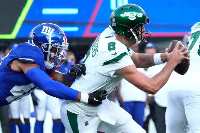 Aug. 26: New York Jets quarterback Aaron Rodgers is pressured by New York Giants inside linebacker Isaiah Simmons.