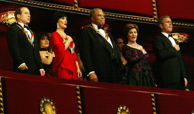 Former U.S. President George W. Bush, right, and first lady Laura Bush, second from right, sing the National Anthem with recipients of the 2002 Kennedy Center Honors, (L-R) Paul Simon, Chita Rivera and James Earl Jones prior to a gala performance Dec. 8, 2002 at the Kennedy Center in Washington.