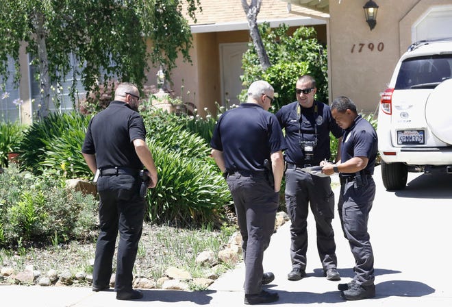 Redding police Investigator Boun Kongkeoviman, right, meets with other officers during their investigation at 1790 Galway Drive in west Redding on Wednesday, June 19, 2019.