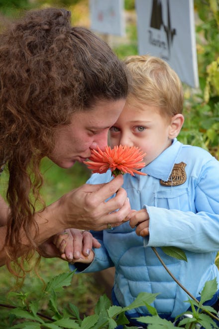 John Myers, 3, enjoys the smell of a flower his mother found at the Dunsmuir Community Garden during the annual Harvest Festival on Friday, Oct. 29, 2021.