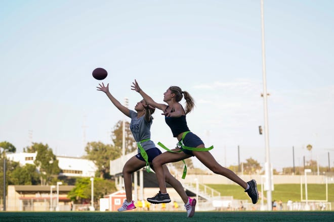 Syndel Murillo, 16, left, and Shale Harris, 15, reach for a pass as they try out for the Redondo Union High School girls flag football team on Thursday, Sept. 1, 2022, in Redondo Beach, Calif. Southern California high school sports officials will meet on Thursday, Sept. 29, to consider making girls flag football an official high school sport. This comes amid growth in the sport at the collegiate level and a push by the NFL to increase interest.