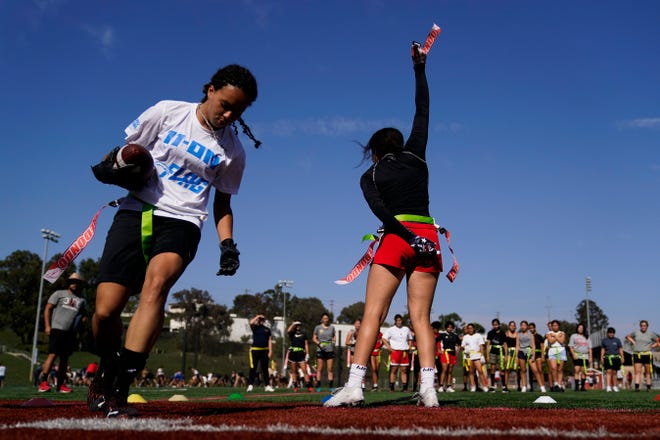 Elsa Morin, 17, right, holds up a flag she pulled from Aaliyah Young, 17, left, as they try out for the Redondo Union High School girls flag football team on Thursday, Sept. 1, 2022, in Redondo Beach, Calif. Southern California high school sports officials will meet on Thursday, Sept. 29, to consider making girls flag football an official high school sport. This comes amid growth in the sport at the collegiate level and a push by the NFL to increase interest.